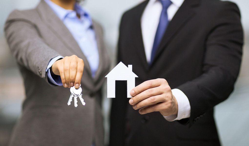 biznes, eko, nieruchomości i koncepcja biura - biznesmen i bizneswoman trzymający biały papierowy dom i klucze w biurze