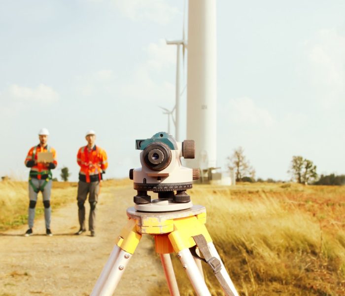 Zespół architektów i geodetów pracujący z teleskopem geodezyjnym do pomiaru wysokości obszarów spacerowych, pomiarów pól wiatrowych, planowania budowy dróg przy użyciu profesjonalnych narzędzi.