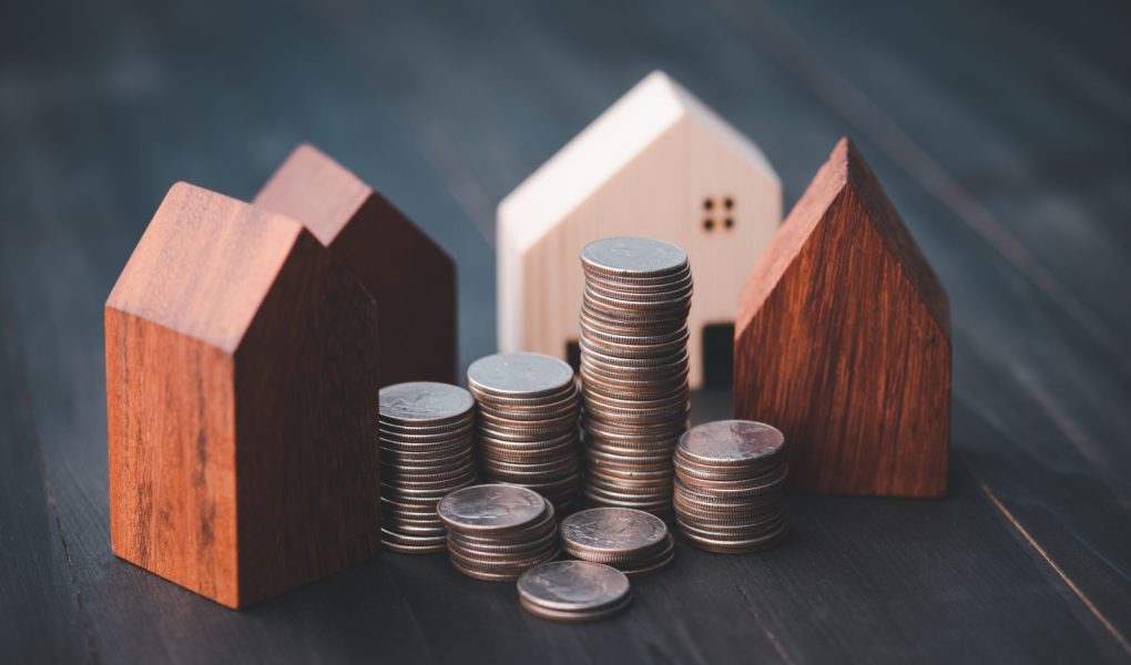 Inwestycja w branży nieruchomości. Wykres rosnącego stosu monet i model domu z drewna. Kredyty na zakup domów mieszkalnych. Oszczędzaj na przyszłość.