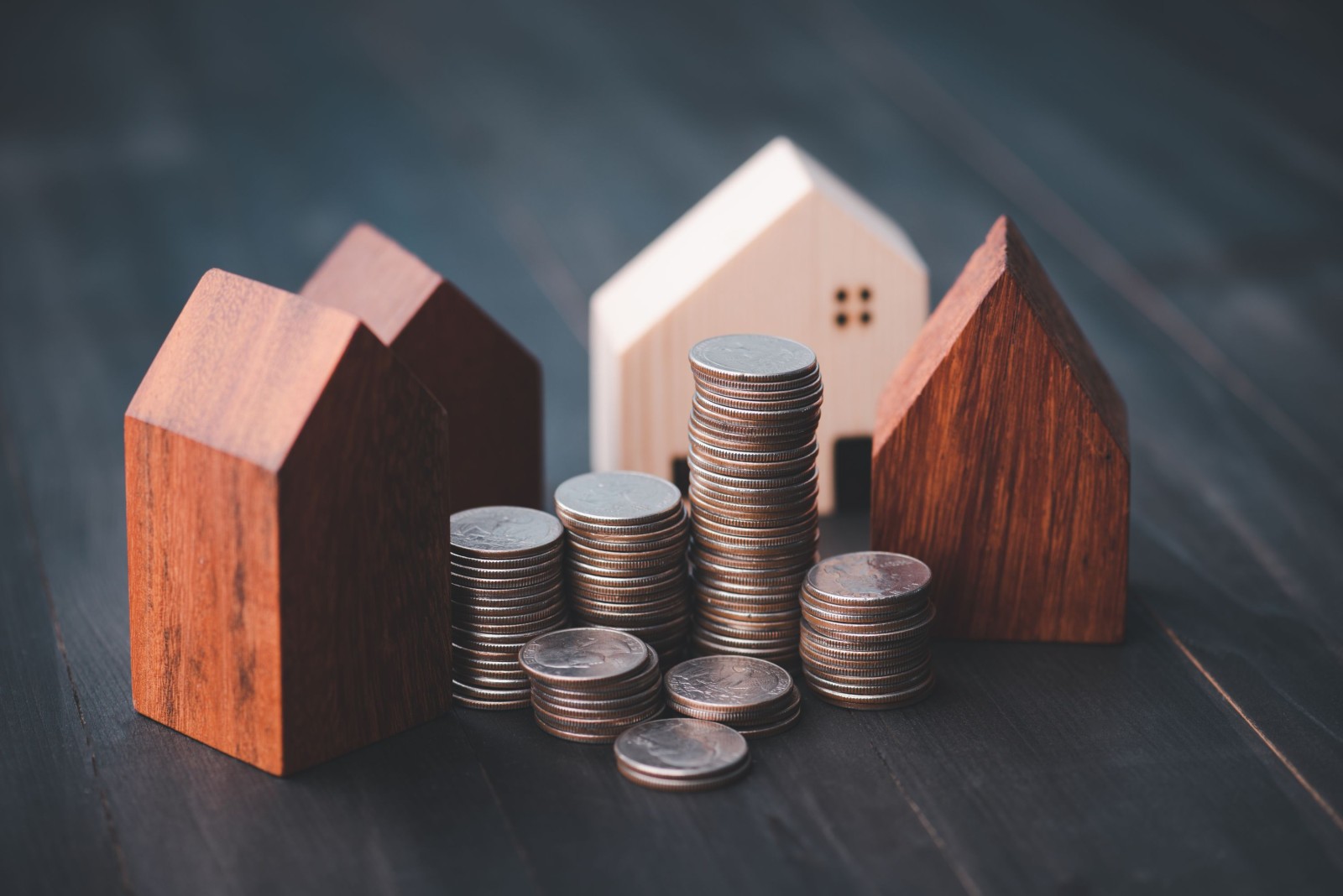Inwestycja w branży nieruchomości. Wykres rosnącego stosu monet i model domu z drewna. Kredyty na zakup domów mieszkalnych. Oszczędzaj na przyszłość.