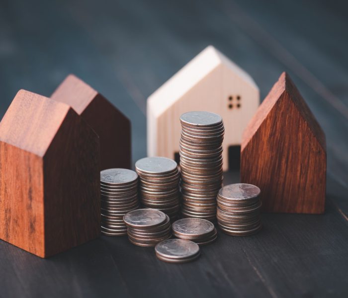 Inwestycja w branży nieruchomości. Wykres rosnącego stosu monet i model domu z drewna. Kredyty na zakup domów mieszkalnych. Oszczędzaj na przyszłość.