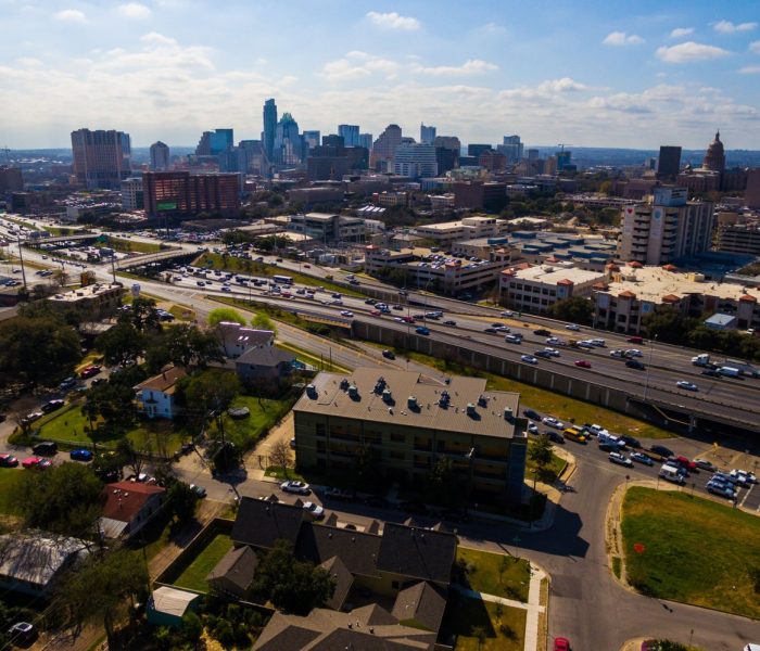 Urban Sprawl Cityscape Skyline z autostradą międzystanową I-35 ruchliwy ruch w słoneczny dzień w letnim rozwijającym się mieście fotografia lotnicza centrum miasta