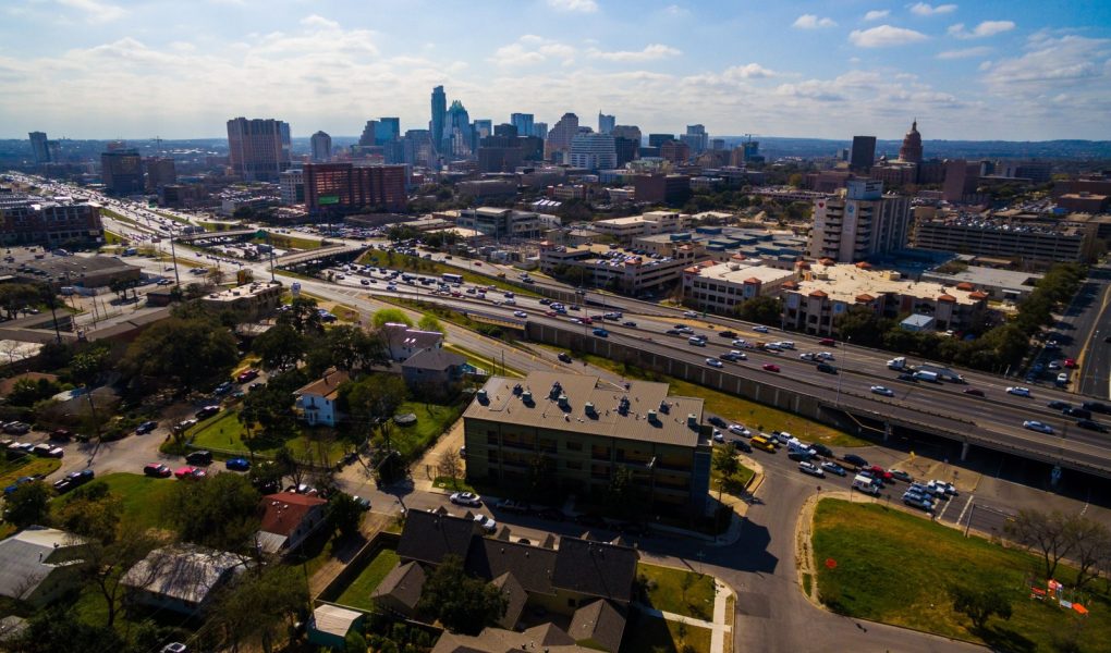 Urban Sprawl Cityscape Skyline z autostradą międzystanową I-35 ruchliwy ruch w słoneczny dzień w letnim rozwijającym się mieście fotografia lotnicza centrum miasta