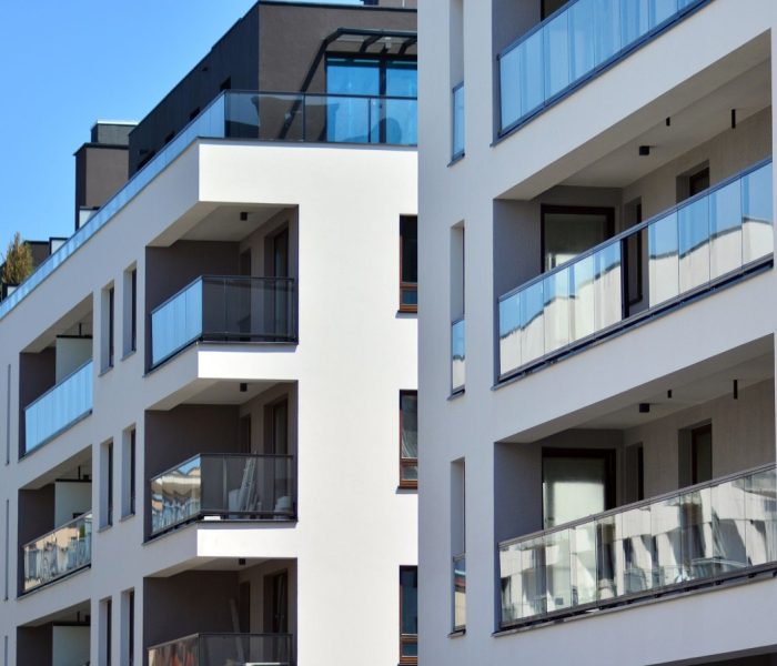 Kondominium i budynek mieszkalny z symetryczną nowoczesną architekturą. Szczegół w nowoczesnym budynku mieszkalnym z apartamentami na zewnątrz. Fragment nowego luksusowego domu i kompleksu domów.