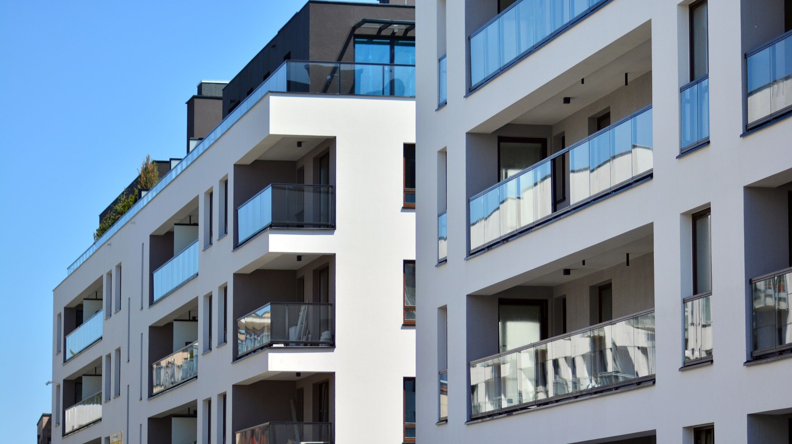 Kondominium i budynek mieszkalny z symetryczną nowoczesną architekturą. Szczegół w nowoczesnym budynku mieszkalnym z apartamentami na zewnątrz. Fragment nowego luksusowego domu i kompleksu domów.