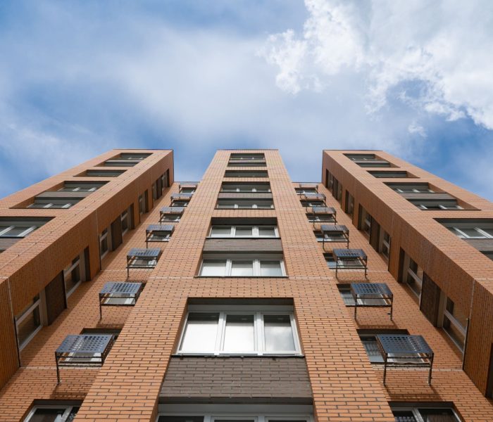 Apartamenty Budynek Wieże. Nowy budynek. Fasada nowych wieżowców mieszkalnych na tle nieba. Koncepcja budowy typowego osiedla mieszkaniowego.