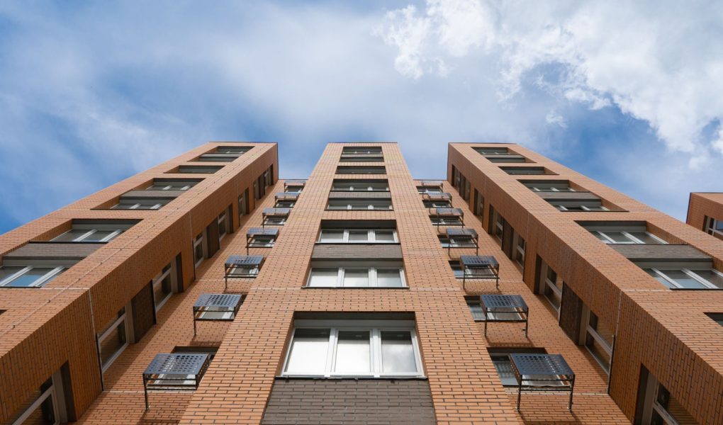 Apartamenty Budynek Wieże. Nowy budynek. Fasada nowych wieżowców mieszkalnych na tle nieba. Koncepcja budowy typowego osiedla mieszkaniowego.