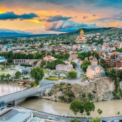 Wieczorny widok na Tbilisi o kolorowym zachodzie słońca, Gruzja. Letni krajobraz miasta. Na zdjęciu widoczna nowa sala koncertowa, rezydencja Avlabar - administracja prezydencka Gruzji, katedra Świętej Trójcy w Tbilisi, kościół Metekhi