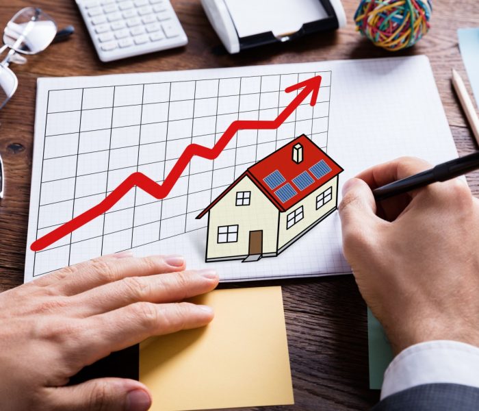 Zbliżenie na biznesmena ręcznie rysującego koncepcję nieruchomości na białym papierze