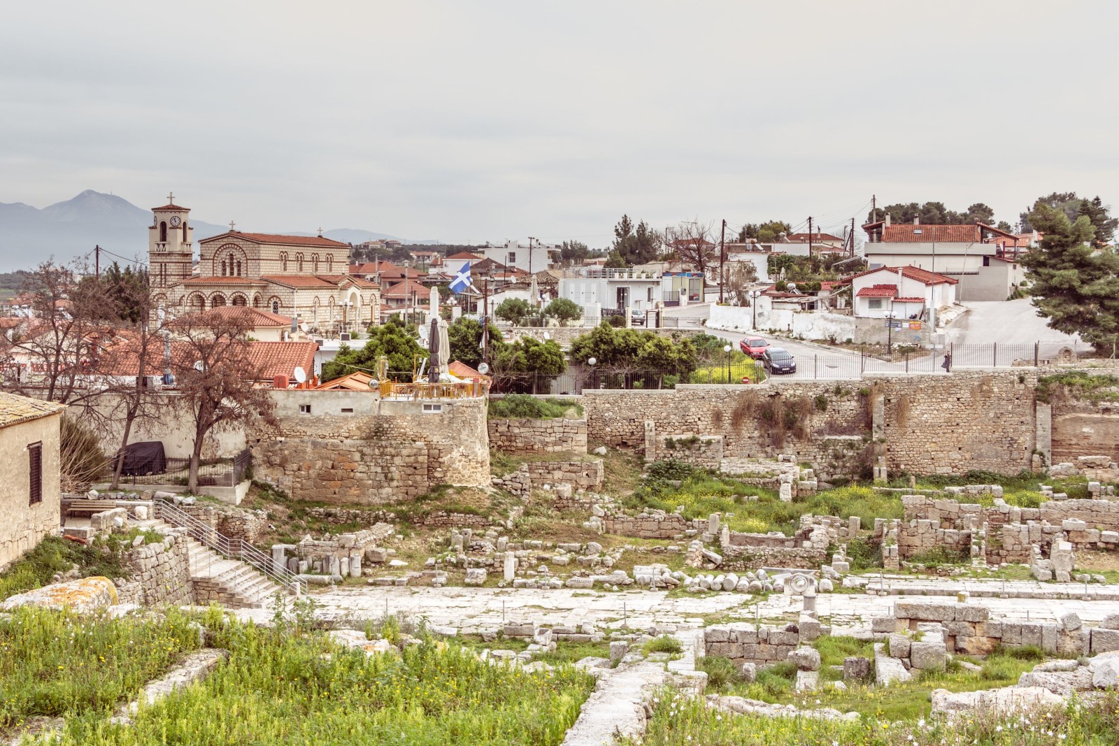 STAROŻYTNY KORYNT, GRECJA - 17 LUTEGO 2016 R: Przegląd małej wioski i parku Starożytny Korynt w Grecji