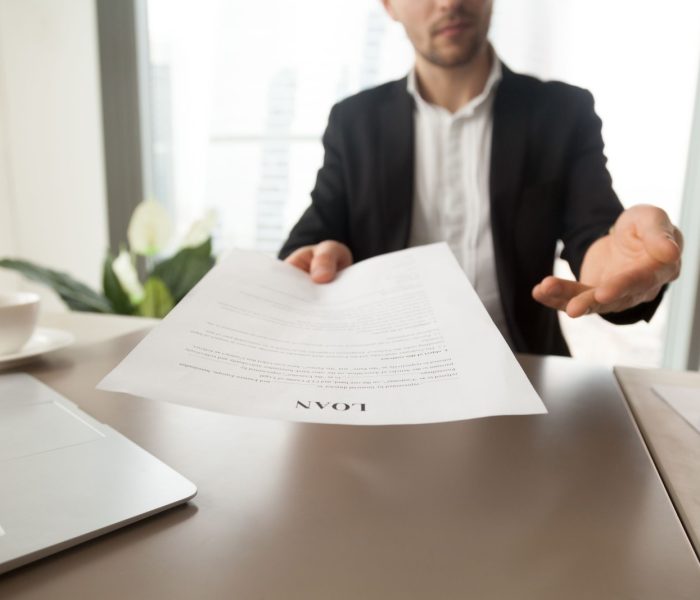 Pracownik banku oferuje przeczytanie i sprawdzenie formularza umowy kredytowej. Doradca finansowy doradza wzięcie kredytu na cele biznesowe, zakup nowego domu. Partner firmy zaprasza do podpisania umowy kredytu hipotecznego. Z bliska