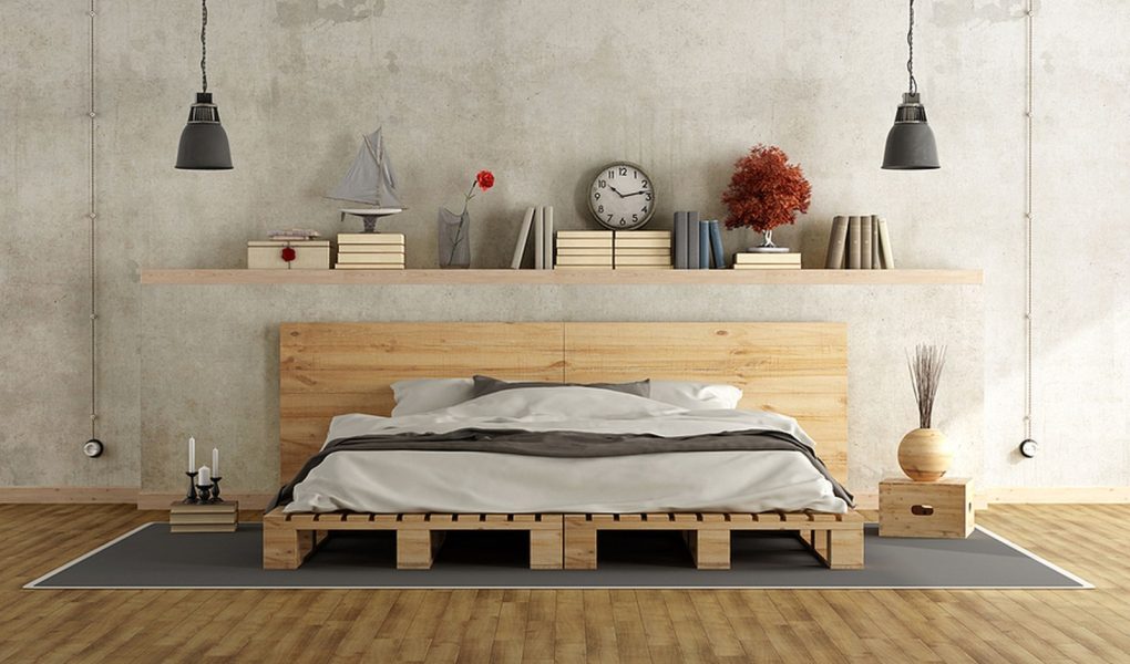 Sypialnia z betonową ścianą, łóżkiem z palet i zabytkowymi przedmiotami na półce - Rendering 3D