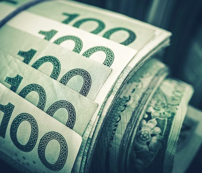 Zrolowane banknoty złotego w zbliżeniu. Koncepcja finansowa polskiej waluty.