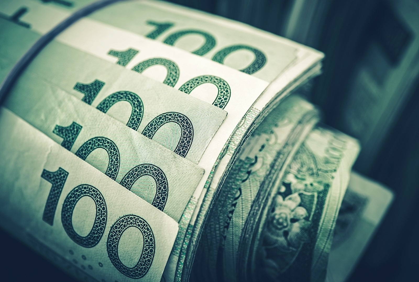 Zrolowane banknoty złotego w zbliżeniu. Koncepcja finansowa polskiej waluty.