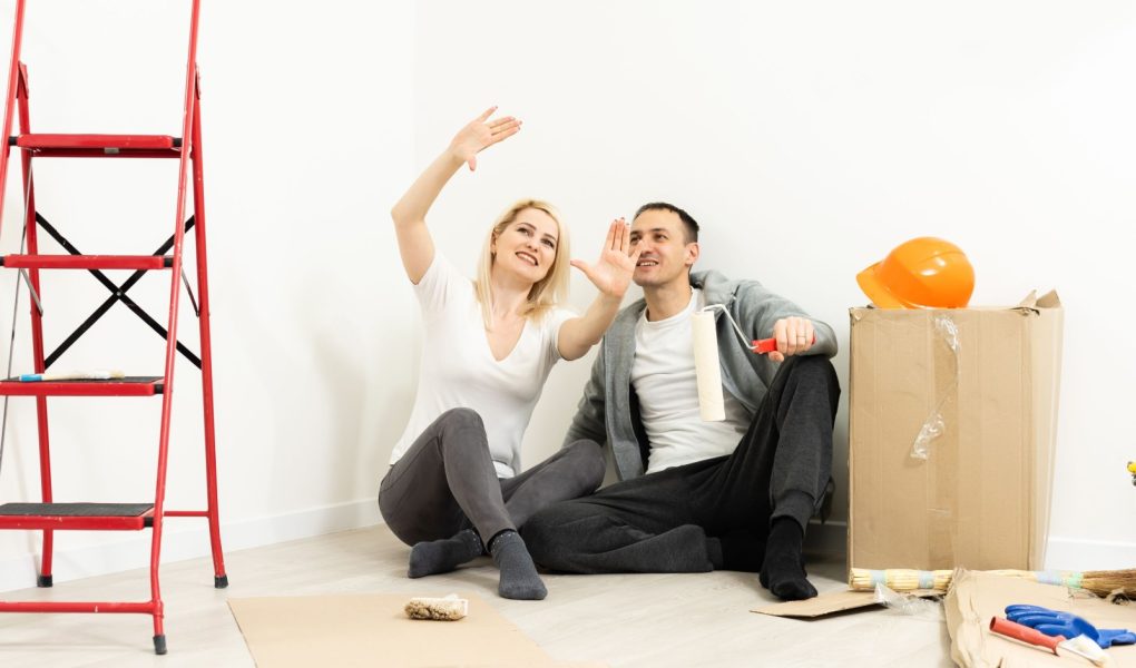 Zbliżenie portretu dorosłej pary siedzącej na podłodze w swoim mieszkaniu i planującej remont nowego mieszkania podczas odpoczynku podczas prac domowych