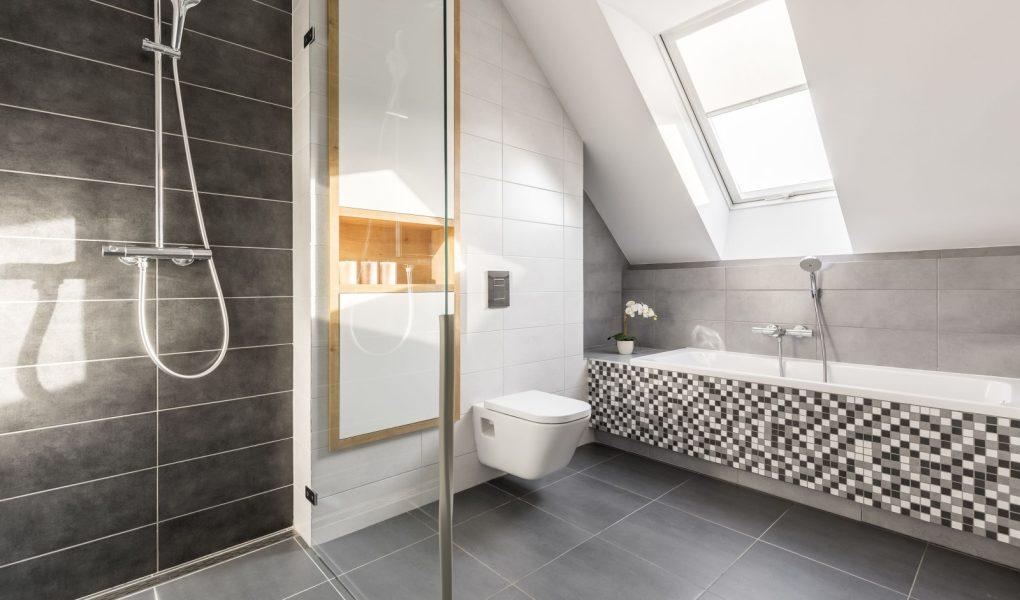 Elegancka łazienka z jasnego kamienia z mozaikową wanną i przestronnym prysznicem