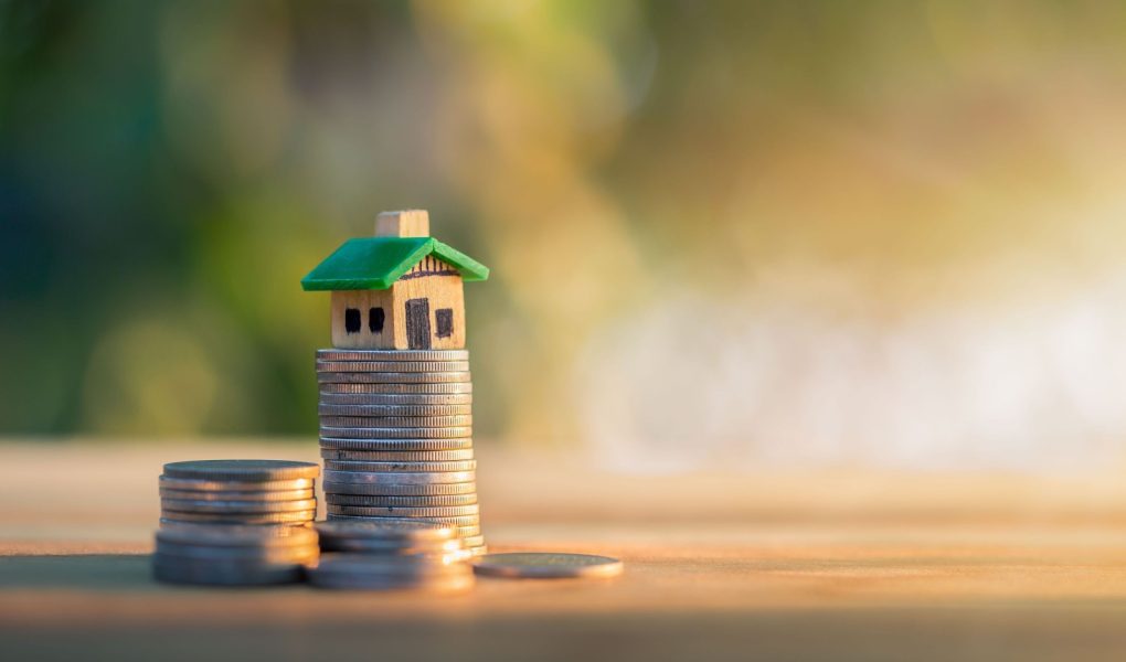 Dom umieszczony na monetach. planowanie oszczędności w monetach na zakup koncepcji domu, koncepcja drabiny nieruchomości, kredytu hipotecznego i inwestycji w nieruchomości. do oszczędzania lub inwestowania w dom.