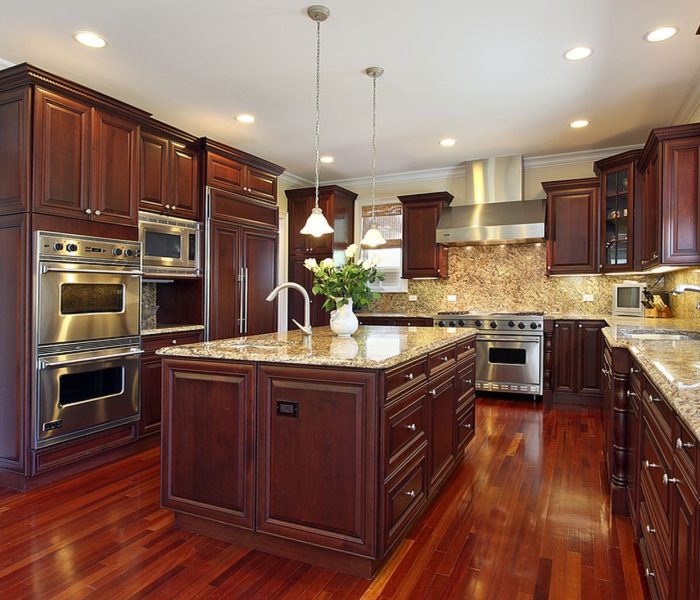 Kuchnia w luksusowym domu z szafkami z drewna wiśniowego