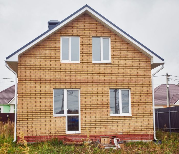 Nowy dwupiętrowy dom z cegły z dwuspadowym dachem.