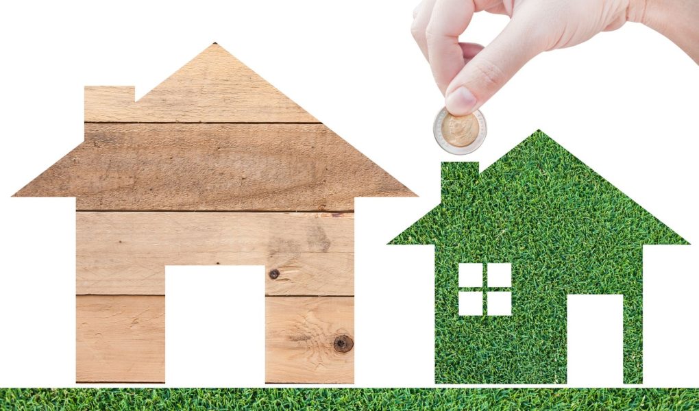 Moneta Ręka trzymająca ikonę domu w naturze jako symbol hipoteki Wymarzony dom na tle natury izolowany na białym tle