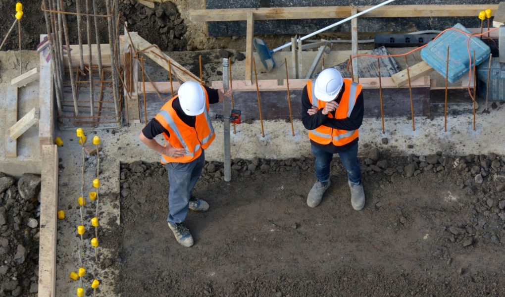 Widok z lotu ptaka na dwóch nierozpoznanych inżynierów budownictwa sprawdzających postęp prac na placu budowy. Koncepcja rozwoju budynku z przestrzenią do kopiowania