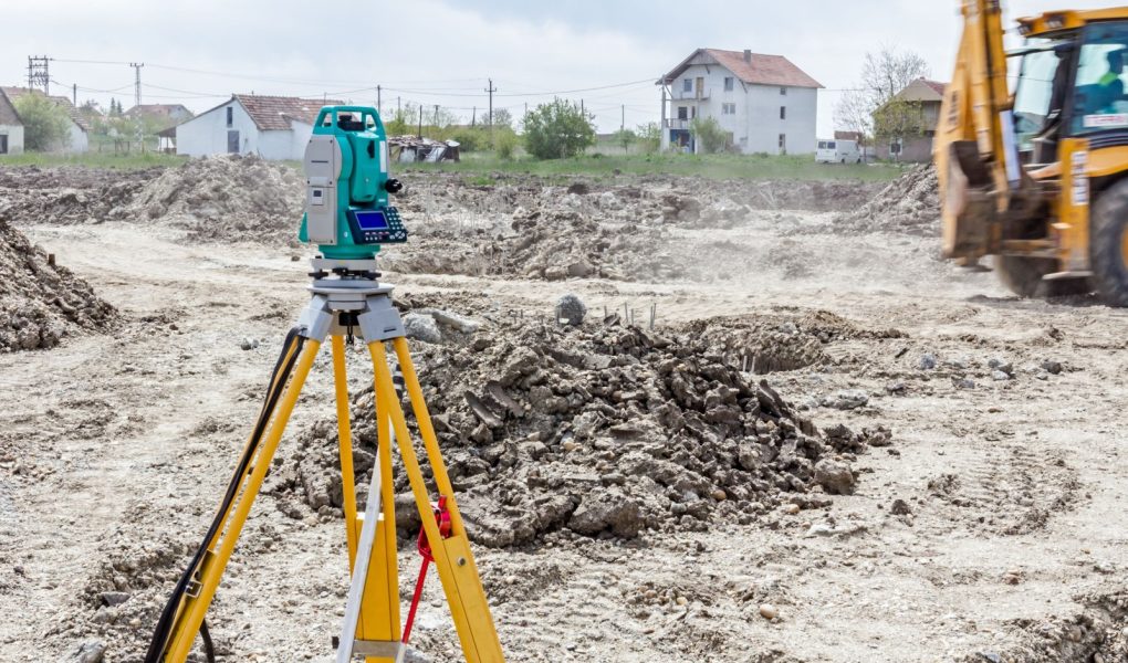 Sprzęt inżyniera geodety do pomiaru poziomu na placu budowy. Geodeci zapewniają precyzyjne pomiary przed rozpoczęciem dużych projektów budowlanych.