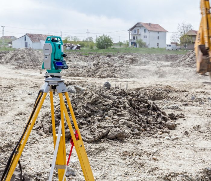 Sprzęt inżyniera geodety do pomiaru poziomu na placu budowy. Geodeci zapewniają precyzyjne pomiary przed rozpoczęciem dużych projektów budowlanych.