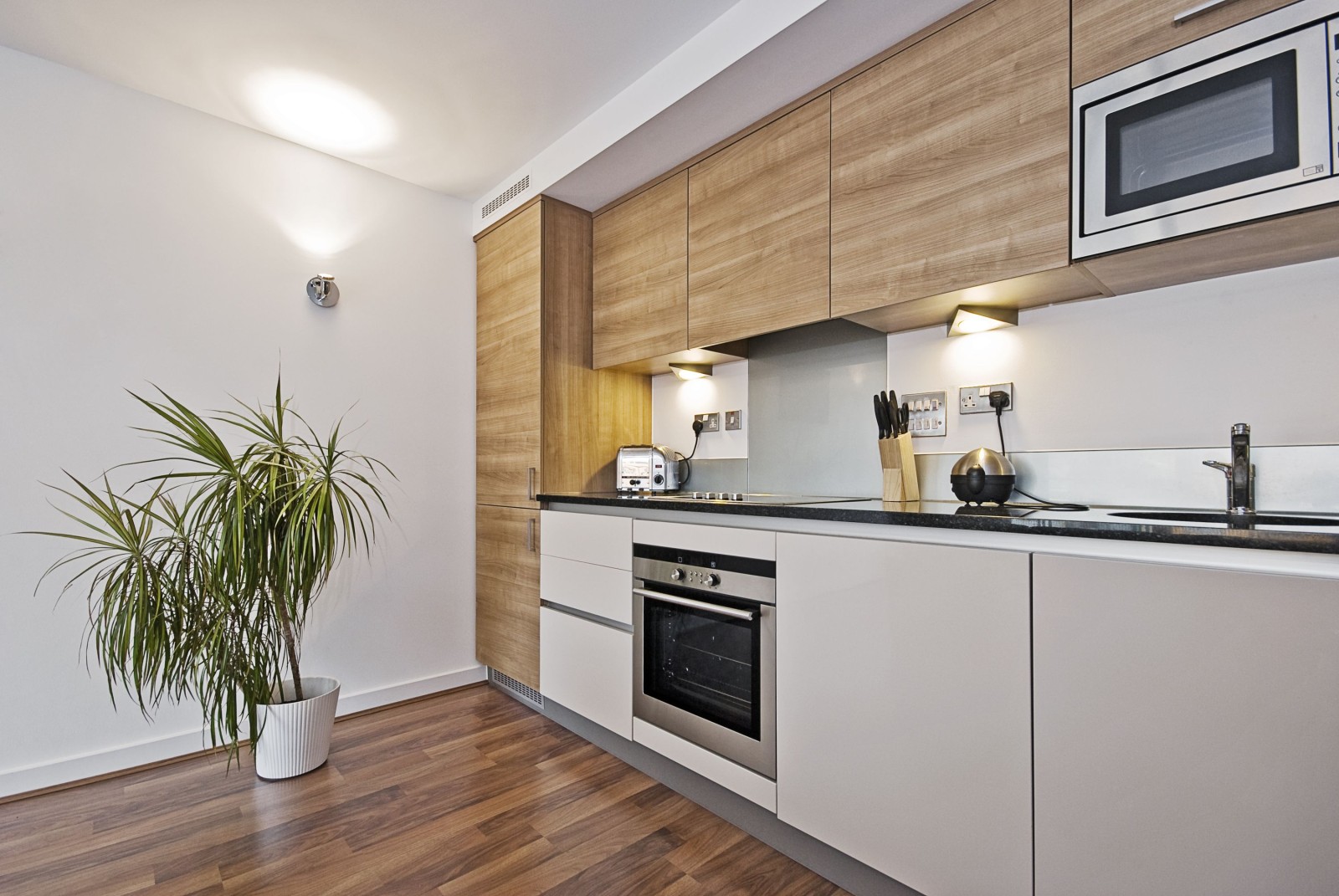 Piękna, nowoczesna kuchnia z wbudowanymi urządzeniami i drewnianą powierzchnią