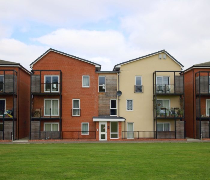 Bracknell, Anglia - 12 kwietnia 2017 r: Widok na zewnątrz nowoczesnego bloku mieszkalnego z balkonami i zieloną przestrzenią z przodu w pochmurny dzień w Bracknell w Anglii