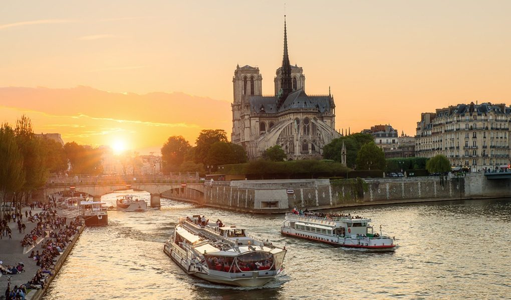 Katedra Notre Dame de Paris ze statkiem wycieczkowym na Sekwanie w Paryżu we Francji. Piękny zachód słońca w Paryżu Francja