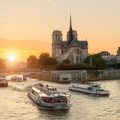 Katedra Notre Dame de Paris ze statkiem wycieczkowym na Sekwanie w Paryżu we Francji. Piękny zachód słońca w Paryżu Francja