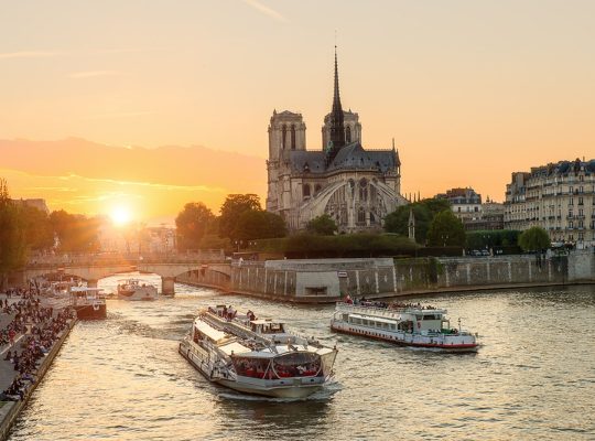 Katedra Notre Dame de Paris ze statkiem wycieczkowym na Sekwanie w Paryżu we Francji. Piękny zachód słońca w Paryżu Francja