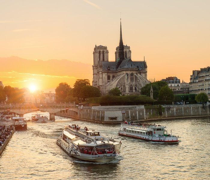 Katedra Notre Dame de Paris ze statkiem wycieczkowym na Sekwanie w Paryżu we Francji. Piękny zachód słońca w Paryżu Francja