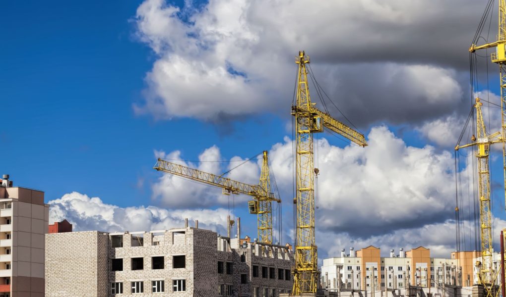 budowa nowego wielokondygnacyjnego budynku mieszkalnego z bloków żelbetowych, plac budowy, obszar działalności związanej z budową i remontem, duże dźwigi budowlane