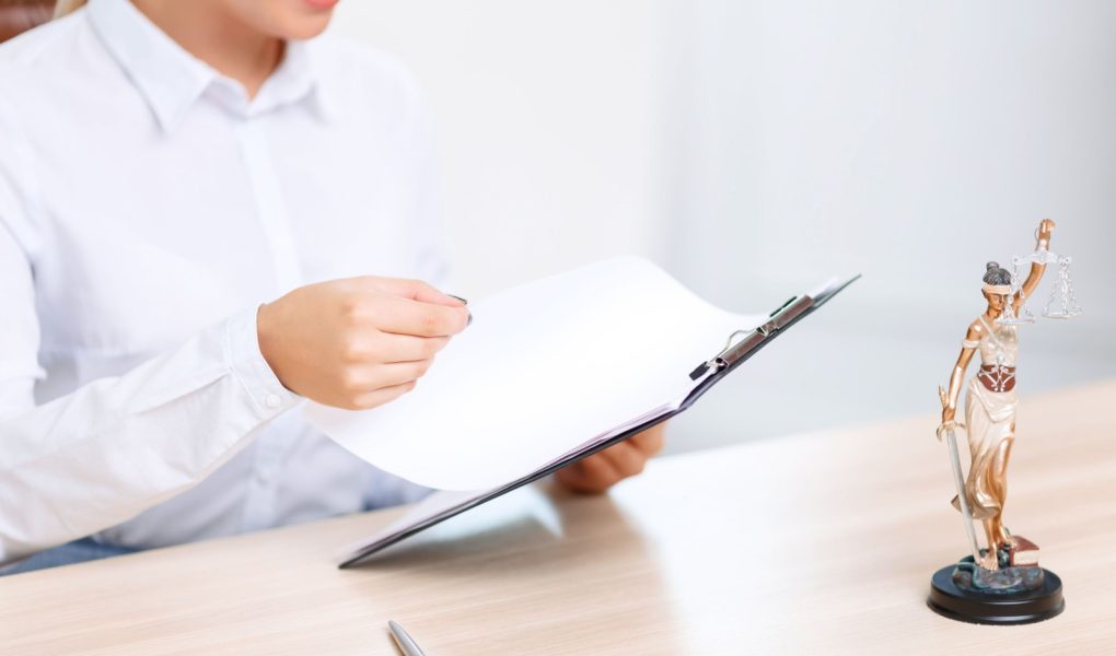 Zajęta w pracy. Profesjonalna prawniczka trzymająca teczkę i siedząca przy stole podczas wykonywania swojej pracy