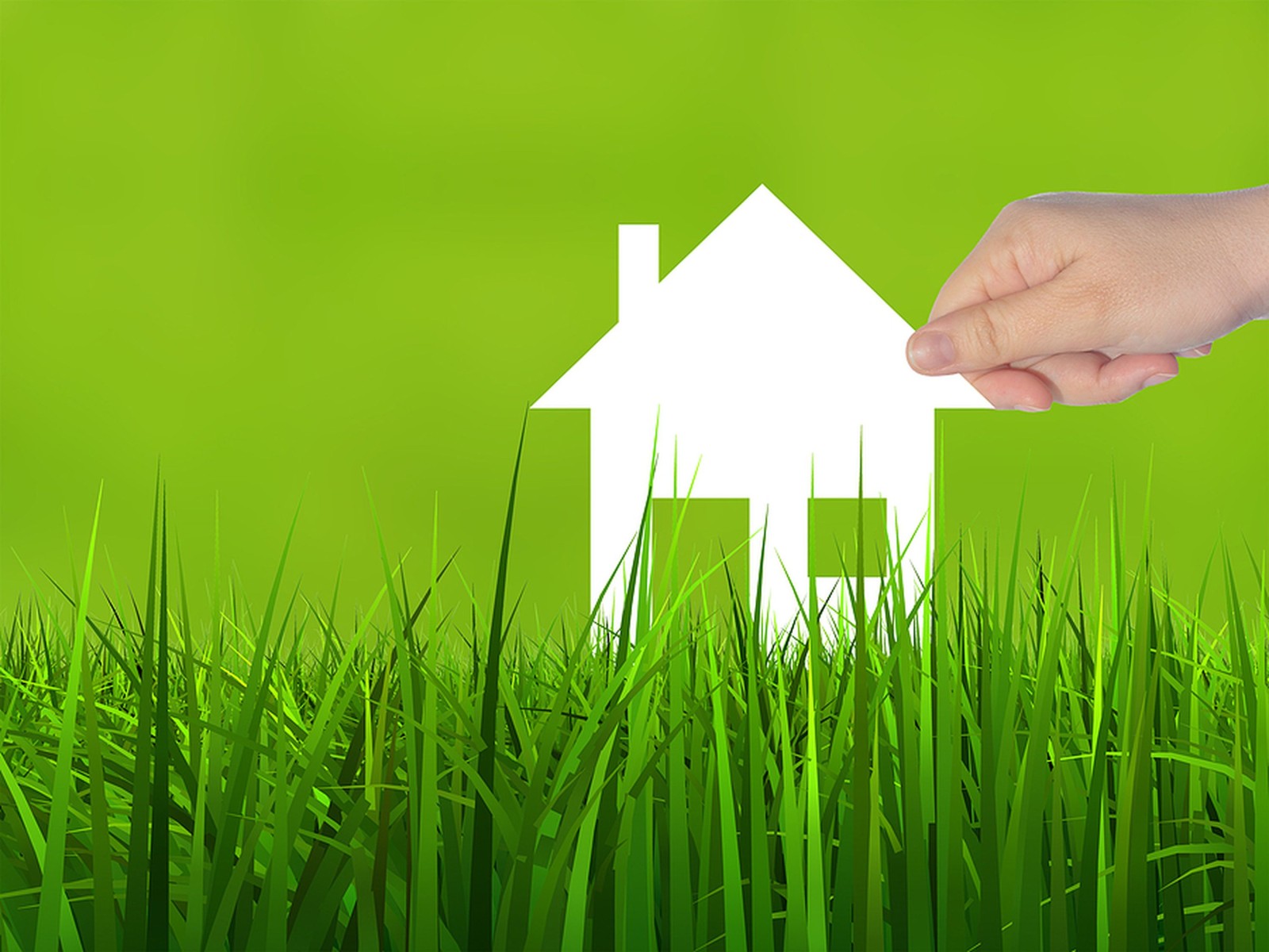 Koncepcja lub koncepcyjny symbol domu z białego papieru trzymany w dłoni przez kobietę na tle zielonej letniej trawy, metafora budownictwa, eko, ekologii, pożyczki, kredytu hipotecznego, nieruchomości, biznesu, inwestycji lub domu