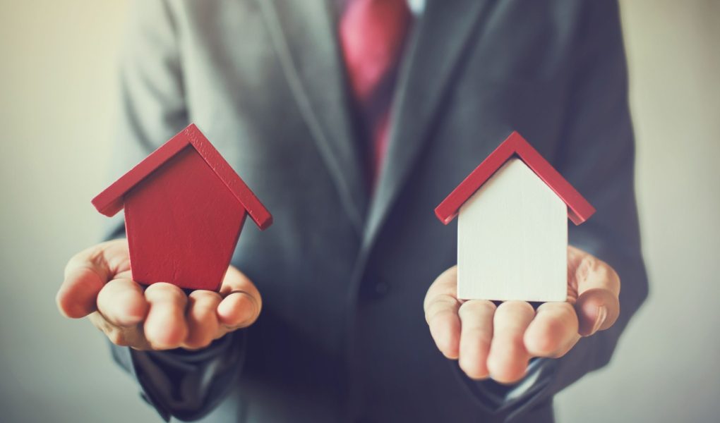 Biznesmen posiadający dwa domy i nie może zdecydować się na wybór odpowiedniego domu.