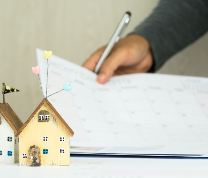 Podpis ludzi biznesu w dokumentach wykres sprawdzający dokument kalendarza w projekcie inwestycji w nieruchomości na biurku. Raport sprzedaży w marketingu hipotecznym w koncepcji nieruchomości. Dwa domy w centrum uwagi