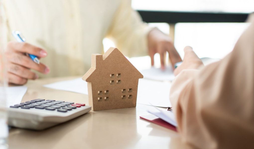 Klient podpisuje dokument pożyczki na zakup domu z agentem nieruchomości lub prawnikiem. Agent nieruchomości i klient podpisujący umowę kupna domu. Koncepcja ubezpieczenia lub pożyczki nieruchomości