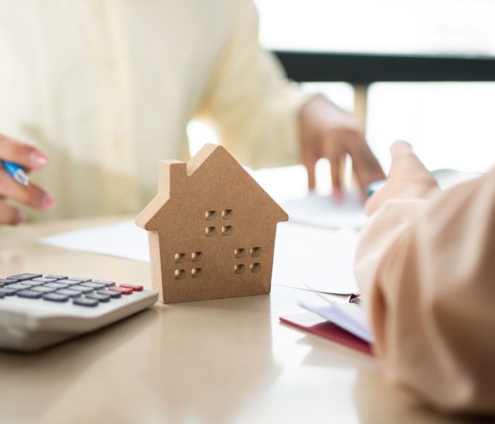 Klient podpisuje dokument pożyczki na zakup domu z agentem nieruchomości lub prawnikiem. Agent nieruchomości i klient podpisujący umowę kupna domu. Koncepcja ubezpieczenia lub pożyczki nieruchomości