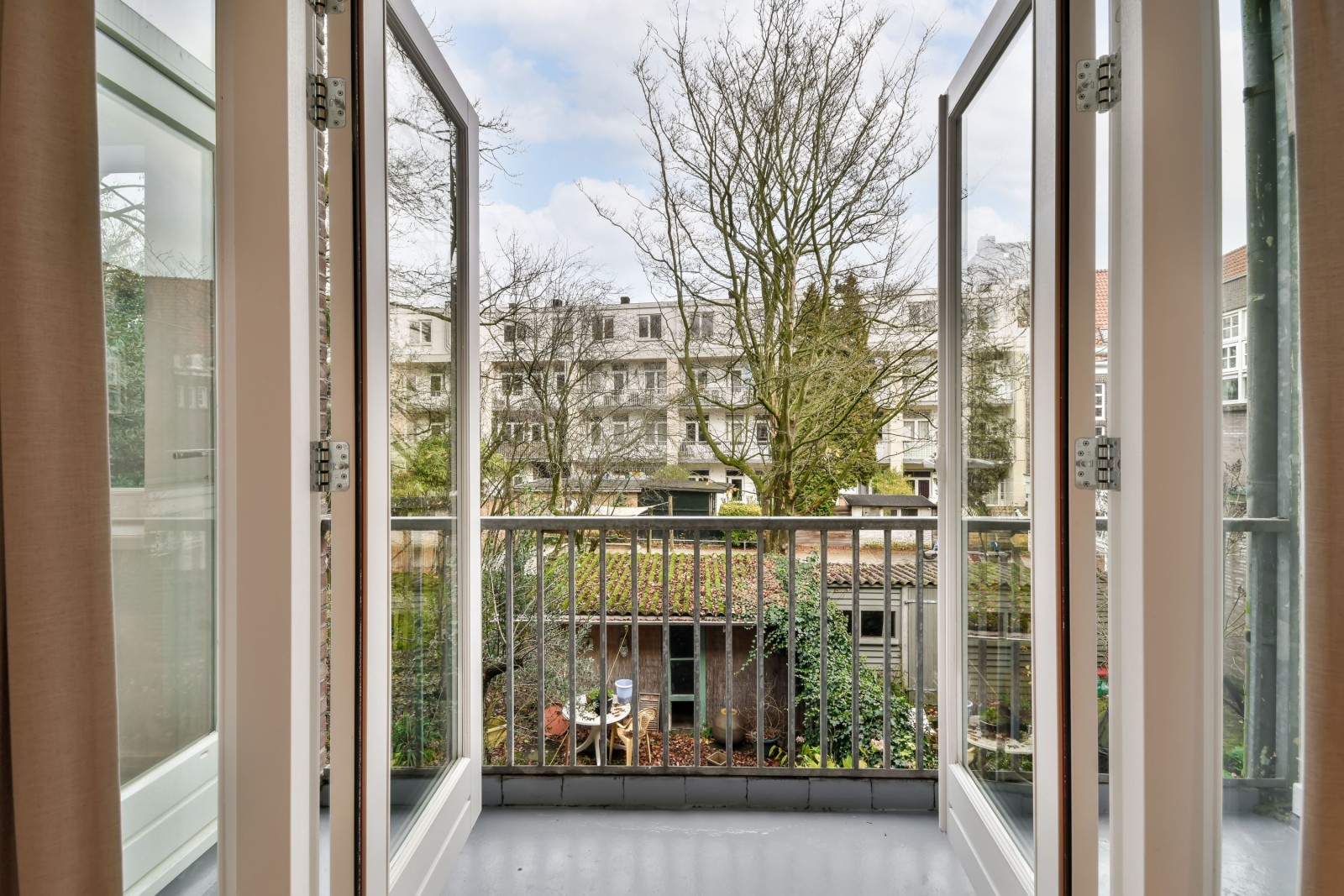 Dostęp do przytulnego balkonu nowoczesnego domu z drewnianymi drzwiami i metalowym ogrodzeniem