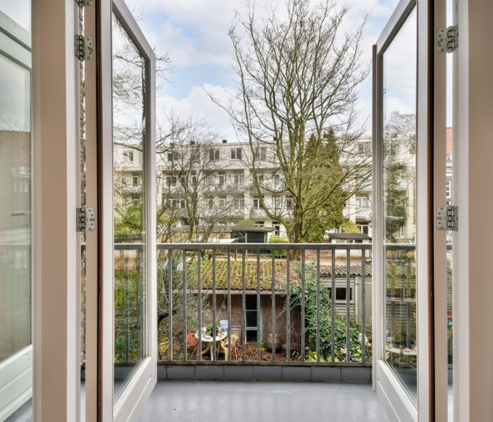 Dostęp do przytulnego balkonu nowoczesnego domu z drewnianymi drzwiami i metalowym ogrodzeniem