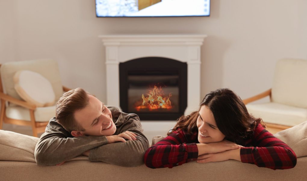 Szczęśliwa, urocza para spędzająca razem czas przy kominku w domu