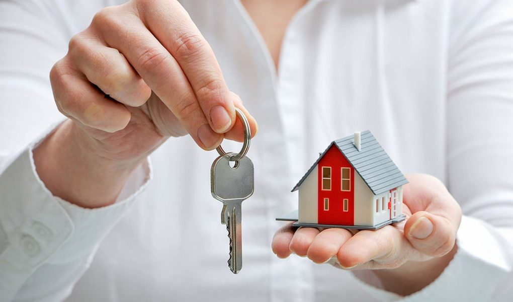 Agent nieruchomości z modelem domu i kluczami