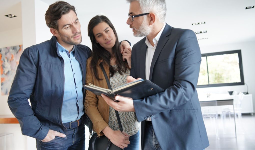 Para z agentem nieruchomości zwiedzająca nowoczesny dom