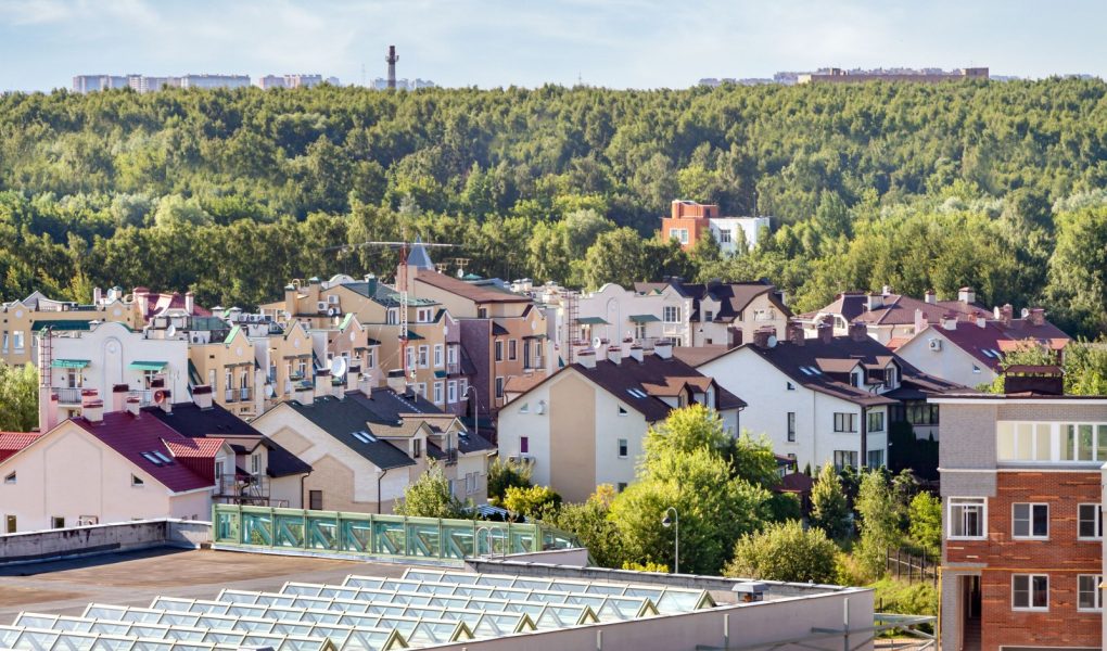 Dom na dachu nowoczesne ustawienia mieszkaniowe mieszane miejskie wielorodzinne dzielnica mieszkaniowa obszar leśny tło.