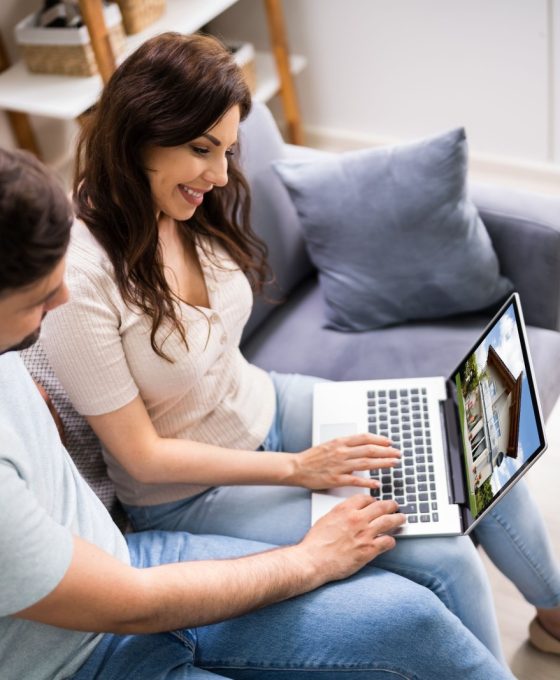 Para wyszukująca nieruchomości online na laptopie