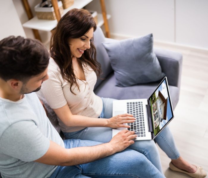 Para wyszukująca nieruchomości online na laptopie