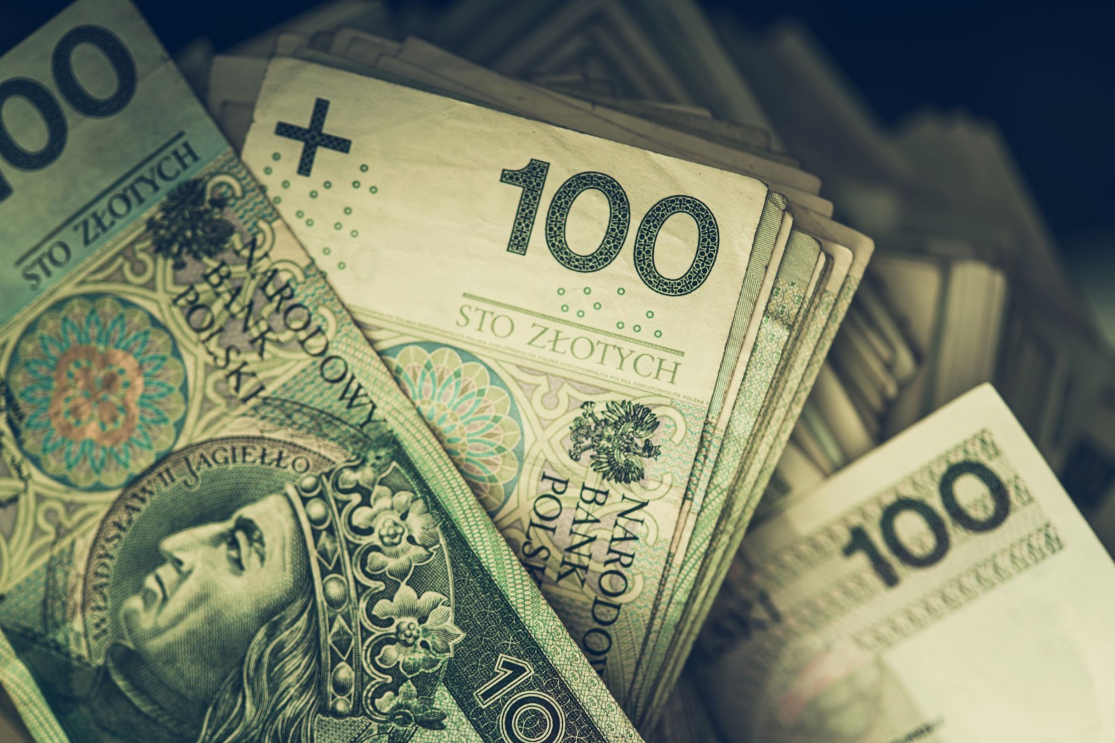 Duży stos polskich złotych w gotówce. Sto banknotów na stole. Temat biznesowy i ekonomiczny.