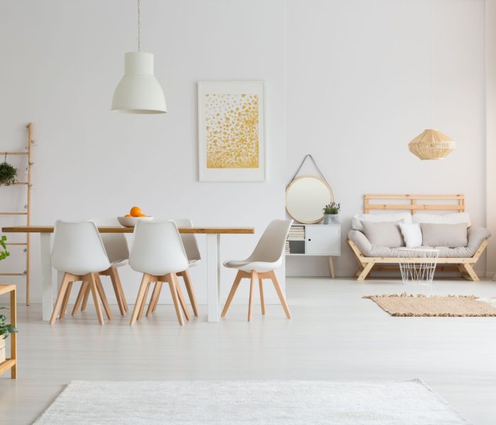 Prosta jadalnia i minimalistyczny salon w białym lofcie lagom